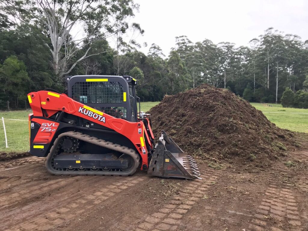 a kubota posi track next to dirt