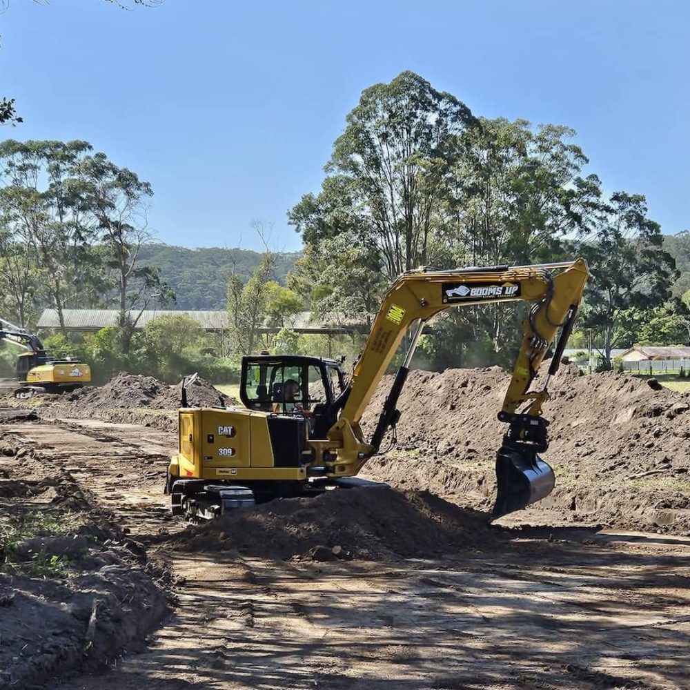 booms up CAT excavator doing earthworks